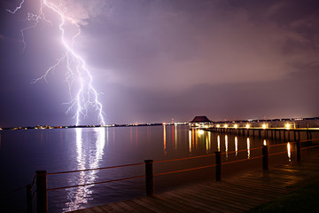 Lightning storm over pier walkway.