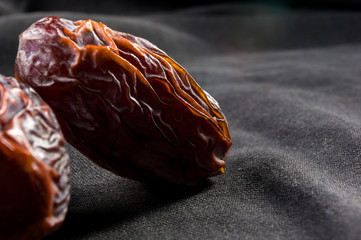 Big luxury dried date fruit on the dark surface, kurma ramadan kareem concept, close up.