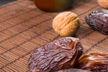 Big luxury dried date fruit on the bamboo mat, kurma ramadan kareem concept, close up.