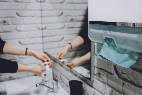 Coronavirus Protection Hand Hygiene. Paper Towels And Alcohol Gel Antibacterial Soap Sanitizer In Bathroom. Woman Washes Her Hands And Wipes With A Paper Towel