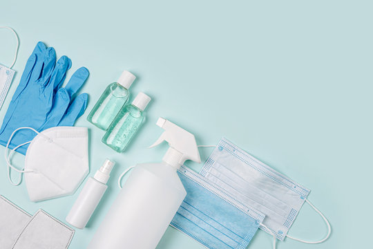 White medical masks and respirators with glove, hand sanitizer on blue background. Face mask protection KN95 or N95 and surgical masks for protection virus, flu, coronavirus, COVID-19.