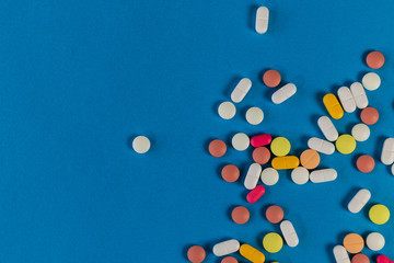 Different medicine pills, tablets on blue background. Many pills and tablets with space for text. Health care. Top view. Copy space. New image. Pharmaceutical picture. Flatlay. Closeup. Background