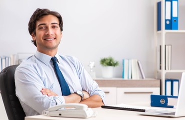 Fototapeta premium Young handsome businessman working in office