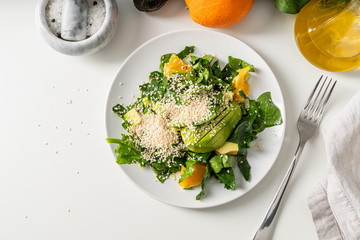 Spinach, avocado and orange salad top view with copy space