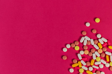 Different medicine pills, tablets on pink background. Many pills and tablets with space for text. Health care. Top view. Copy space. New image. Pharmaceutical picture. Flatlay. Good background