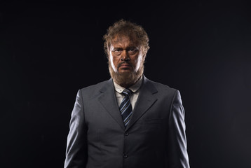 Fototapeta premium portrait of a dirty loser businessman on a black background