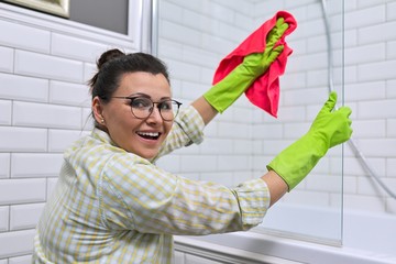 Female cleaning polishing shower glass with a washcloth with microfiber