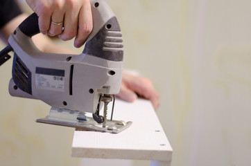 Worker's hands holding a drill making holes on a body plane 