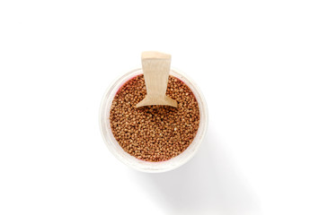 buckwheat in a plastic jar. wooden spoon in buckwheat.