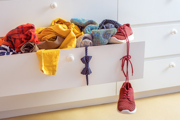 organization and storage of clothes at home, an open chest of drawers with a bunch of bright...