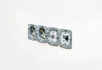 Internal sockets without frame against a background of white plaster wall