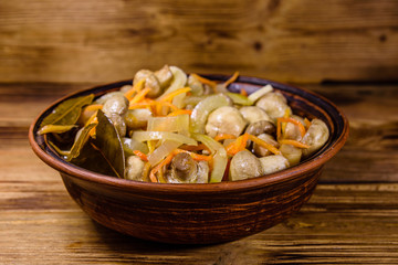 Canned mushrooms with carrot and onion in a ceramic bowl