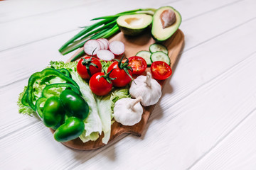 Tomatoes, cucumber, garlic, fresh herbs, radish, avocado on chop