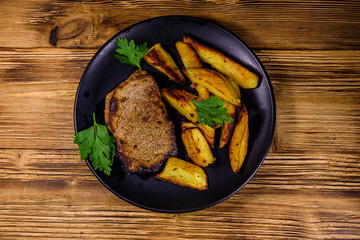 Roasted beefsteak with the fried potato and parsley. Top view