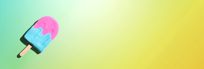 Pink and blue popsicle with shadow - overhead view