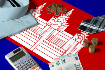 Cambodia flag on minimal money concept table. Coins and financial objects on flag surface. National economy theme.