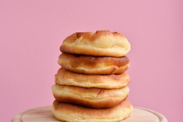Stacked homemade hamburger buns on the pink backdrop