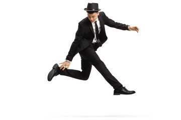 Fototapeta na wymiar Young man in a suit in a jumping dance pose