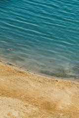 The expanse of the sea meets the sandy beach. Aerial view from quad copter