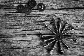 viti e ferramenta in bianco e nero sfondo in legno