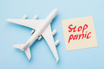Toy airplane and a note with text on a blue background, top view. Fear of flying concept
