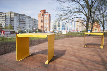 Recreation area and yellow metal chairs in a public city park