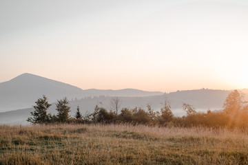 Smoky mountain landscape with mountain and light rays before sunset.
