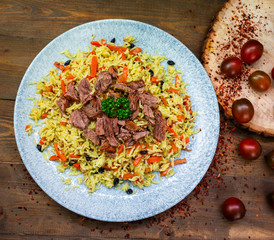 Samarkand pilaf on the Uzbek plate and chuk chuk salad on the wooden background