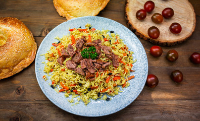 Samarkand pilaf on the Uzbek plate and chuk chuk salad on the wooden background