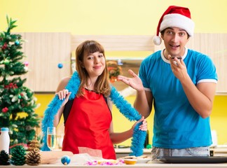 Young couple celebrating Christmas in kitchen