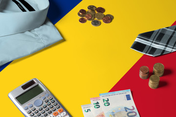 Romania flag on minimal money concept table. Coins and financial objects on flag surface. National economy theme.