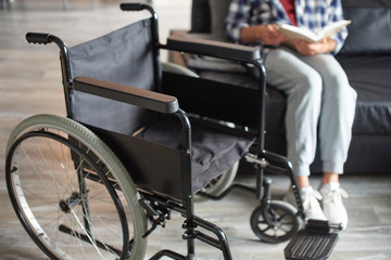 Disabled man sitting near wheelchair alone