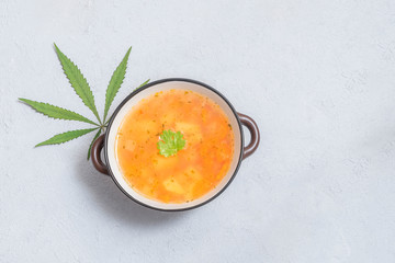 Marijuana-infused soup in a bowl with cannabis leaf