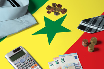 Senegal flag on minimal money concept table. Coins and financial objects on flag surface. National economy theme.