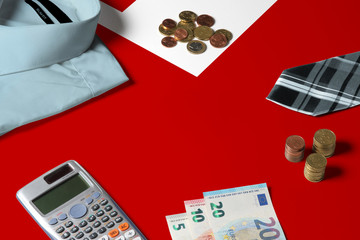 Tonga flag on minimal money concept table. Coins and financial objects on flag surface. National economy theme.