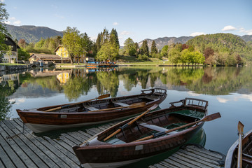Naklejka na ściany i meble Bled, Sloveina, April 22, 2020: Lake shore with all the boats tied to the dock, due to coronavirus lockdown. Tourism in for trouble.