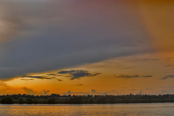 View of the large coastal zone, sandy shore, trees on the horizon, the stage and the Volga River at sunset.