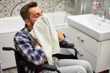 Handicapped man washing face in bathroom