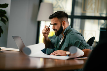 Handsome man working in office. Young man working on project.