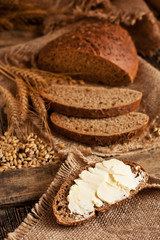Slice of rye bread with butter on wooden board