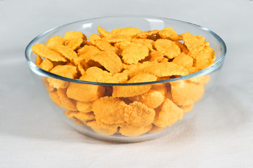 Cornflakes in a plate close-up on a white background, ready tasty breakfast