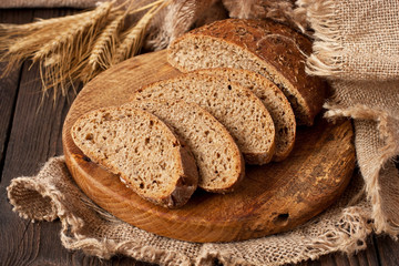 Delicious rye  bread with crispy crust  on wooden board