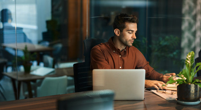 Businessman Working Alone In An Office At Night