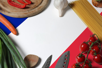 France flag on fresh vegetables and knife concept wooden table. Cooking concept with preparing background theme.
