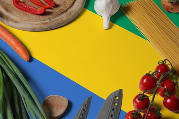 Gabon flag on fresh vegetables and knife concept wooden table. Cooking concept with preparing...