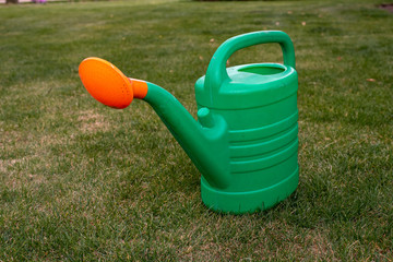 green watering can with orange tip