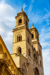 Low-angle high section street view of the Altamura Cathedral or Cathedral of Santa Maria Assunta bell towers in Altamura, Apulia, Italy