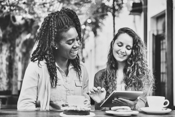 Two girlfriends watch the tablet at the Coffee Bakery shop