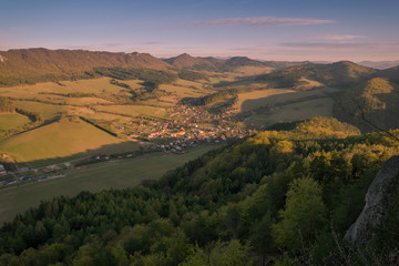 View of the countryside under the mountains at sunset.
