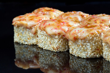 Sushi rolls with squid, mussel and cheese on a black background.